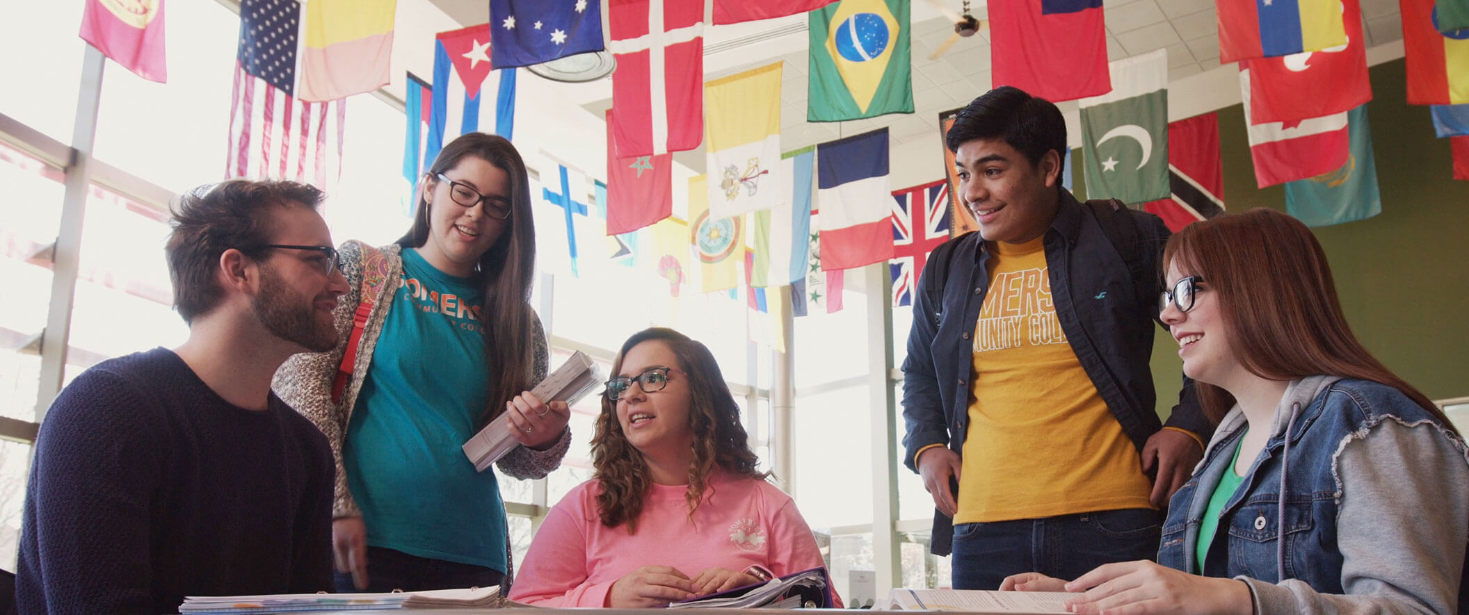five students in building with international flags